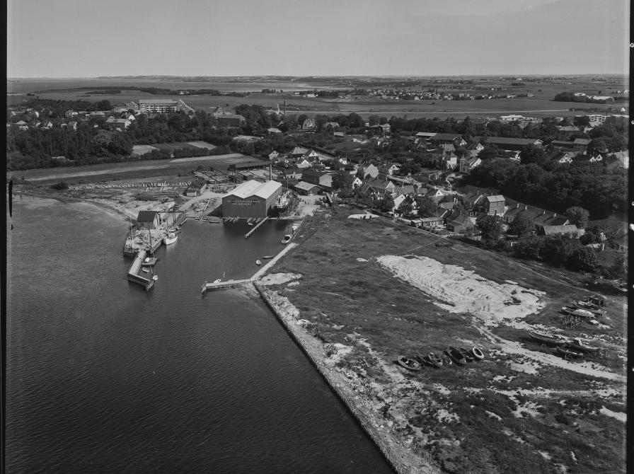 Sort/hvid luftfoto af Frederikssund Skibsværft 1956 set fra vandet